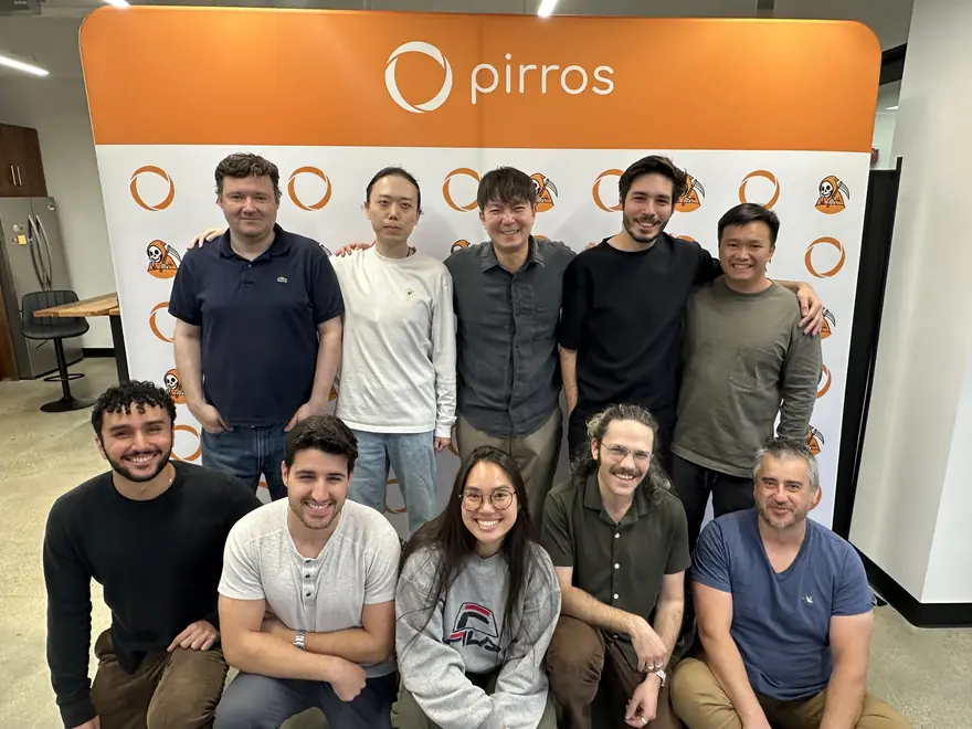 The team gathered in front of a Pirros banner